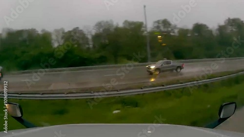 U.S. truck jackknifed during a heavy rainstorm, showcasing the dangers of wet roads and poor visibility photo
