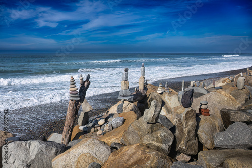 2024-01-15 STACKED ROCKS ON THE ROCKY SHORELINE AT THE TORREY PINES STATEA APRK WITH THE PACIFI OCEAN IN THE BACKGROUND NEAR LA JOLLA CALIFORNIA photo