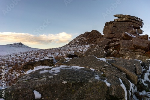 winter in the mountains, formation in Dartmoor during sunset, rocks covered by snow photo