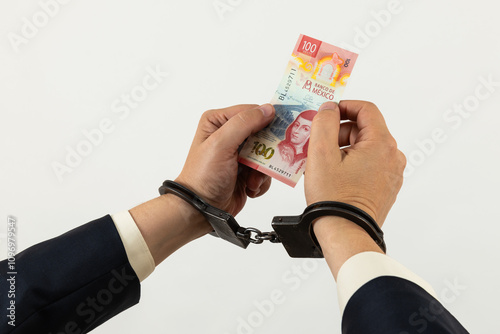 Hands of a businessman in handcuffs and a 100 Mexican pesos bill photo