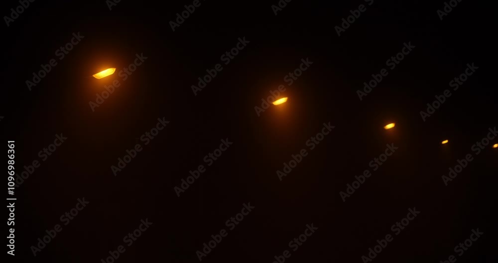 Street lamps cast a warm glow through dense fog on a tranquil road, creating a peaceful nighttime atmosphere. The quiet setting invites reflection and calm. Street lamps cast a warm glow through dense fog on a tranquil road, creating a peaceful nighttime atmosphere. The quiet setting invites reflection and calm.