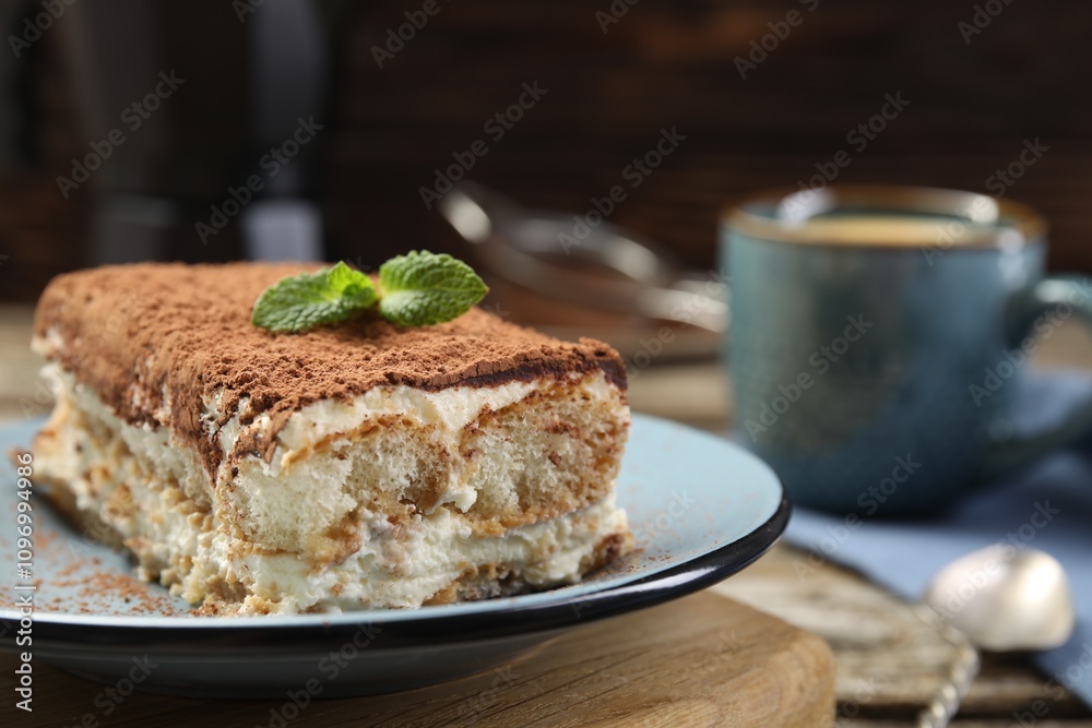 Piece of tasty tiramisu on wooden table, closeup Piece of tasty tiramisu on wooden table, closeup