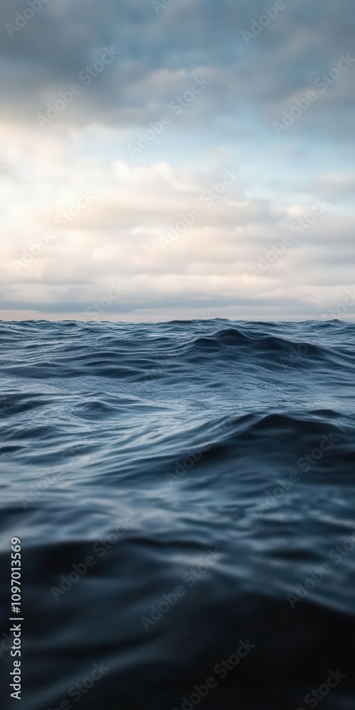 Calm ocean waves under a cloudy sky during sunrise Calm ocean waves under a cloudy sky during sunrise