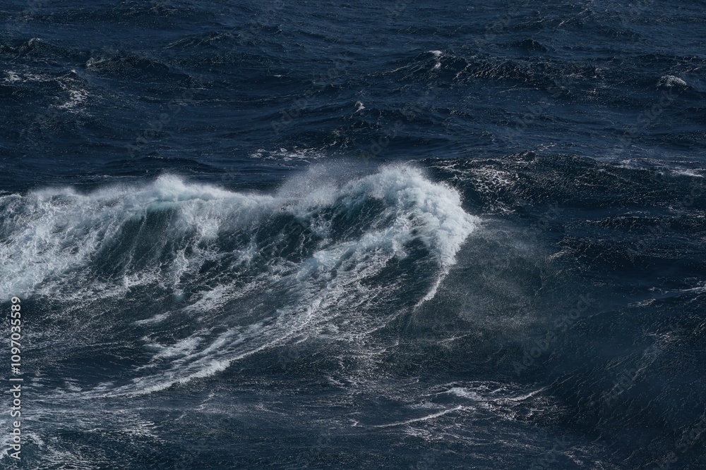 powerful ocean waves crash against each other, creating dramatic scene of turbulent water and frothy white caps. deep blue hues of sea evoke sense of awe and respect for nature force powerful ocean waves crash against each other, creating dramatic scene of turbulent water and frothy white caps. deep blue hues of sea evoke sense of awe and respect for nature force