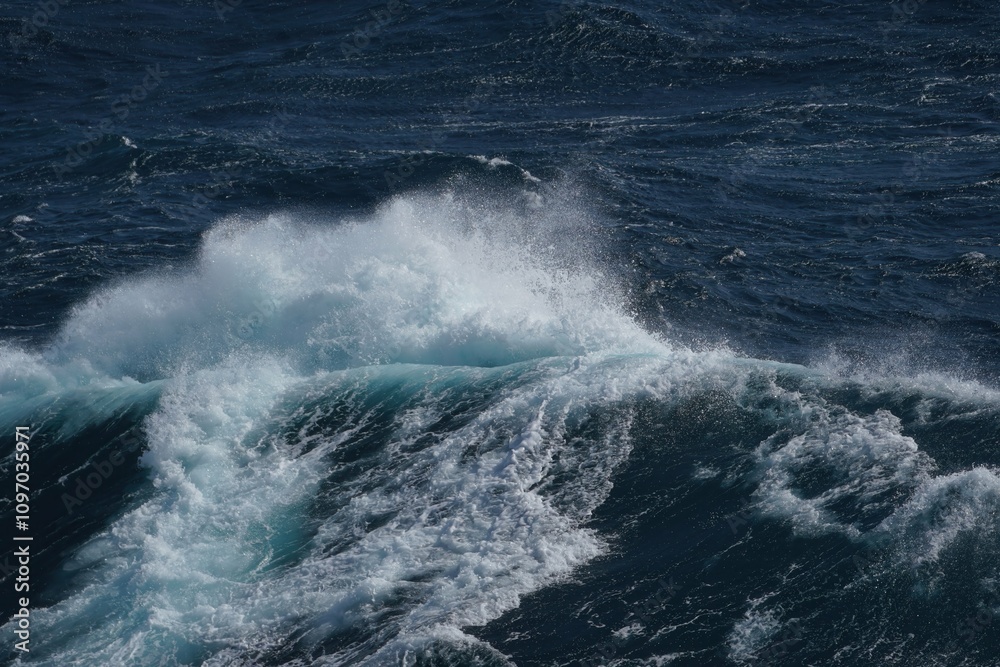 Dynamic ocean waves crashing with white foam against deep blue sea, creating sense of power and tranquility Dynamic ocean waves crashing with white foam against deep blue sea, creating sense of power and tranquility