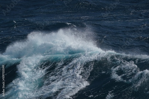 Majestic ocean waves crashing with white foam against deep blue sea, creating dynamic and powerful scene. energy of water is captivating and evokes sense of tranquility