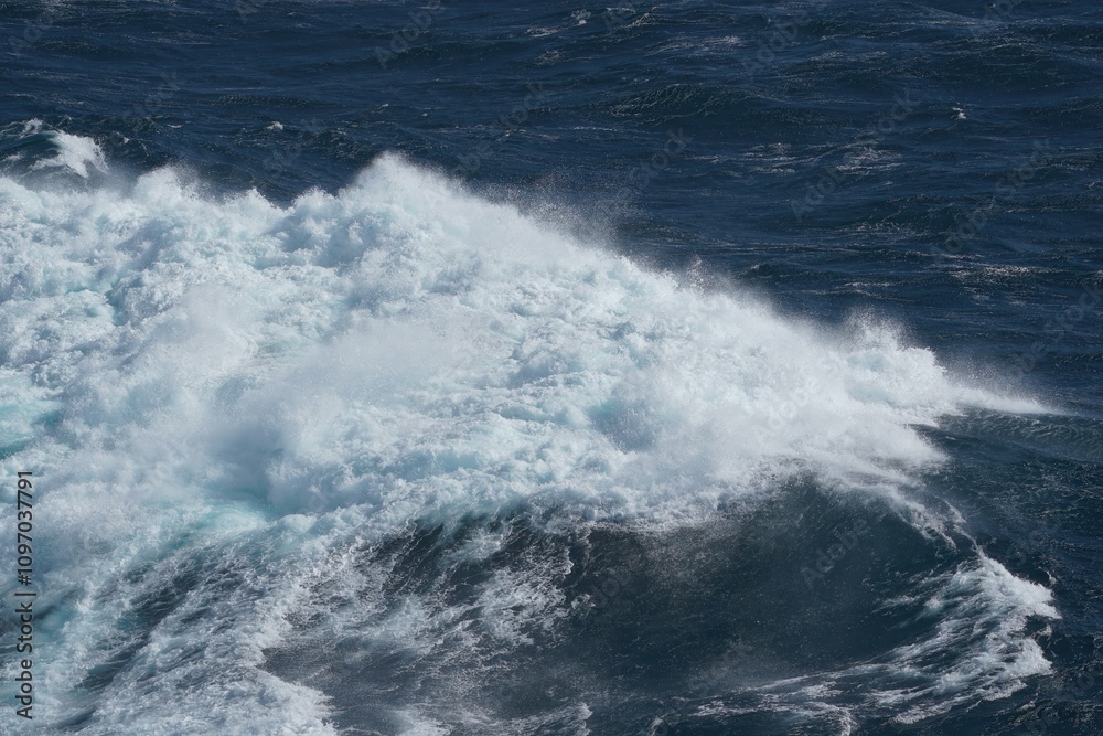 Powerful ocean waves crashing against each other, creating stunning display of white foam and deep blue water, showcasing beauty and force of nature Powerful ocean waves crashing against each other, creating stunning display of white foam and deep blue water, showcasing beauty and force of nature