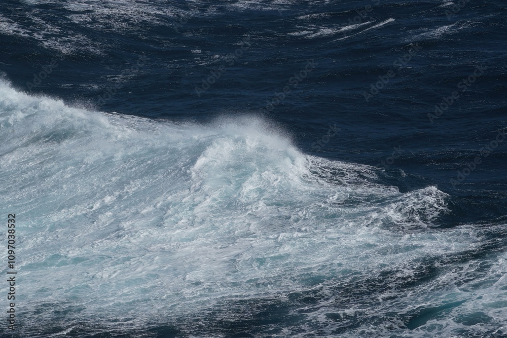 Ocean waves crashing against rocky shore, creating dynamic seascape filled with energy and movement. deep blue water contrasts beautifully with white foam Ocean waves crashing against rocky shore, creating dynamic seascape filled with energy and movement. deep blue water contrasts beautifully with white foam