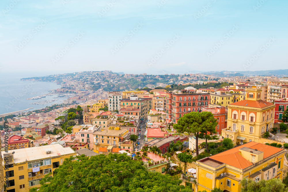 Fototapeta premium Captured from Sant'Elmo Castle, this photo reveals Naples’ vast cityscape, historic architecture, and iconic Mount Vesuvius framed by the Italian sky