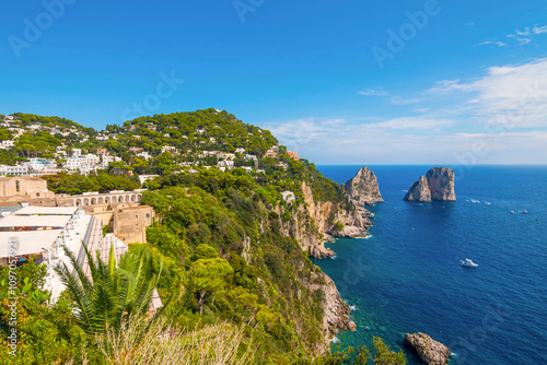 The photo of a breathtaking view of the town of Capri, highlighting the Gardens of Augustus with their vibrant flowers and greenery, set against the backdrop of the coastline. Italy