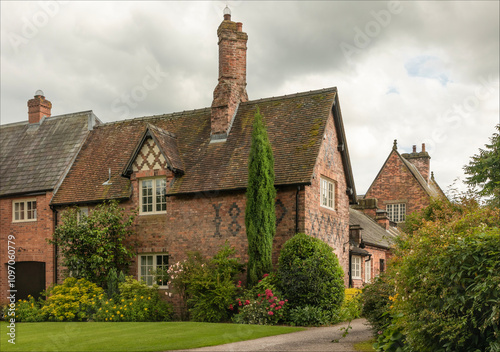 Ancient house in the grounds of a stately home with a manicured garden on a cloudy day