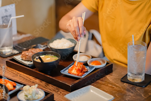 Woman hand holding chopsticks for eating Kimchi salad in restaurant. Japan food traditional Kimchi