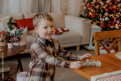 Cute smiling boy on Christmas tree background with toy train