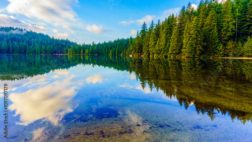 Reflections on placid Sasamat Lake, BC, Canada.