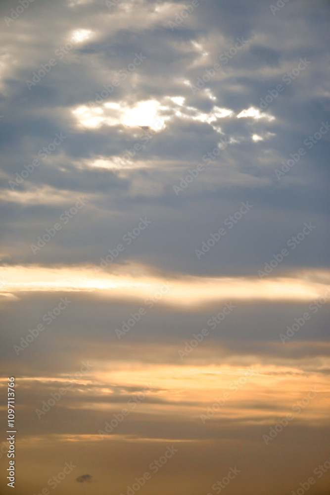 Fototapeta premium Serene sky with clouds and soft colors at dusk, creating a peaceful atmosphere.