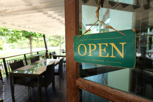 A welcoming open sign on a cafe, inviting customers to enjoy a delightful experience.