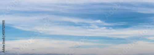 Blue sky covered with white layered clouds in sunny weather