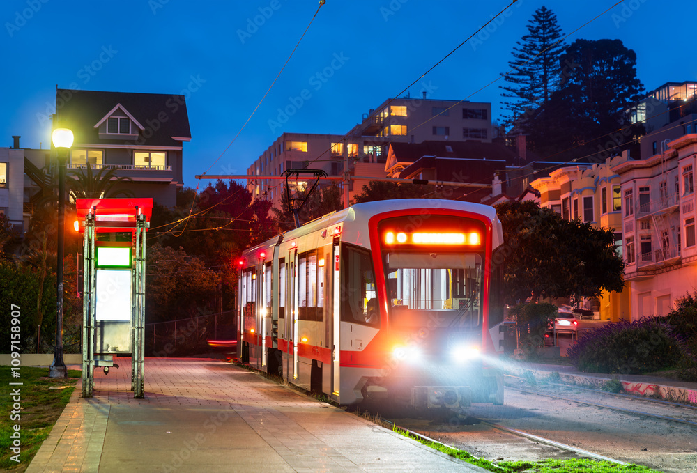 Fototapeta premium Light Rail Streetcar Stopped at Mission Dolores Park at Night in San Francisco, California, USA