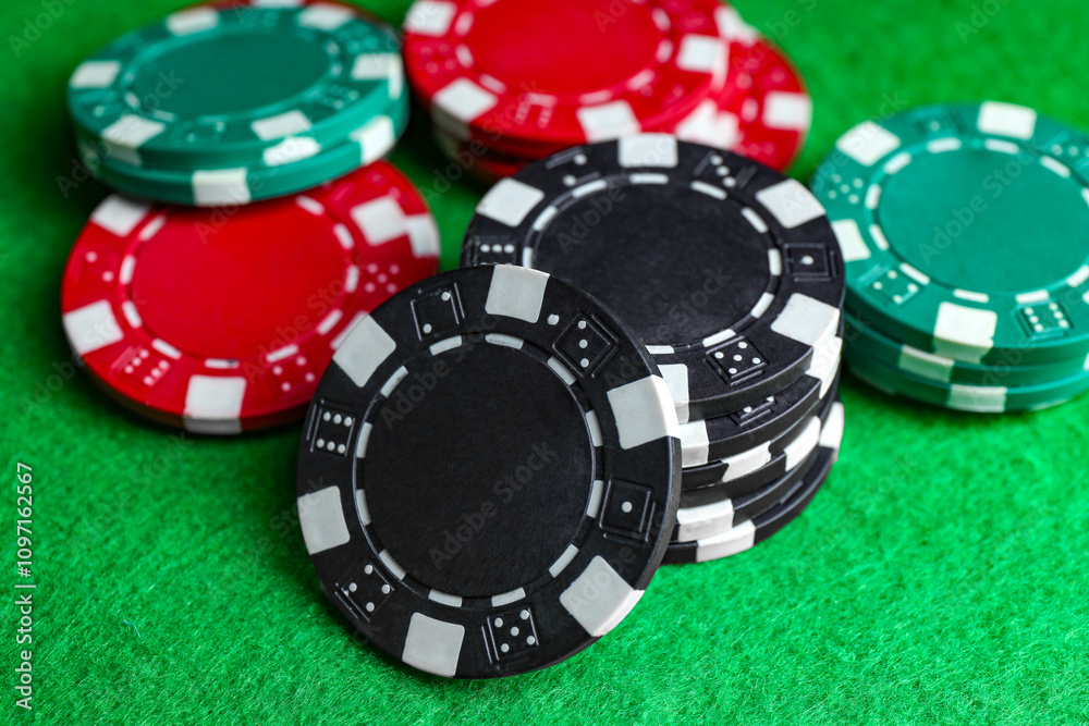 Poker game. Casino chips on green table, closeup Poker game. Casino chips on green table, closeup