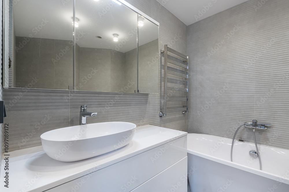 A bright bathroom with a mirrored cabinet over a bowl-sink with a white pedestal. A bright bathroom with a mirrored cabinet over a bowl-sink with a white pedestal.