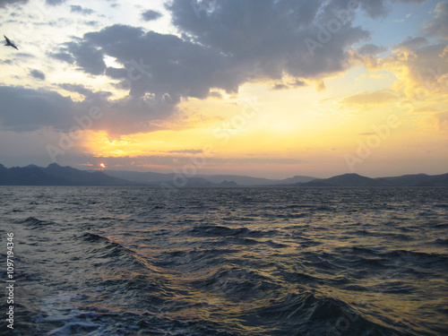 seascape coral sunset on the background of mountains and sea waves