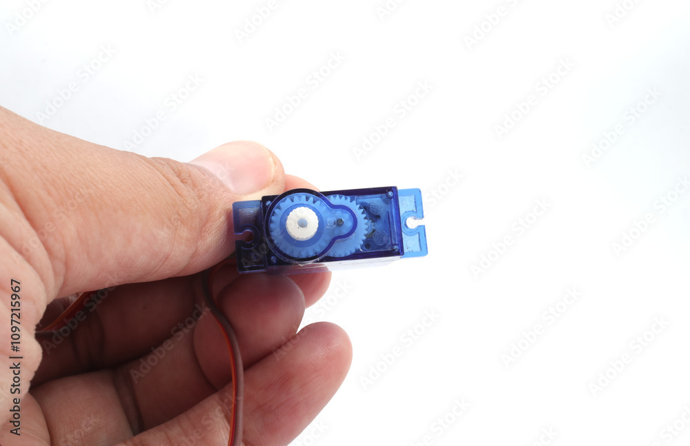 A blue plastic micro servo is held in hand on a white background. Used by electronics, mechatronics, robotics, and remote control hobbyists. A blue plastic micro servo is held in hand on a white background. Used by electronics, mechatronics, robotics, and remote control hobbyists.