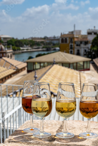 Sherry wine tasting on roof of old Triana district in Sevilla with view on Sevilla houses and churches, wine glasses