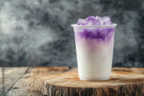 Disposable glass of iced taro tea with winter melon and fresh milk on a wooden board side view photo