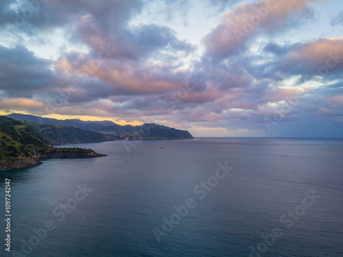 Aerial drone view of sunset over Azores islands. Ribeira Quente and Praia do Fogo. Landscape of Sao Miguel coastline with green mountains in Azores