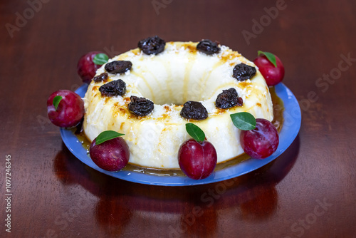 Traditional Brazilian coconut flan dessert known as manjar branco, manjar de coco and manjar dos deuses. Served with plum syrup. photo