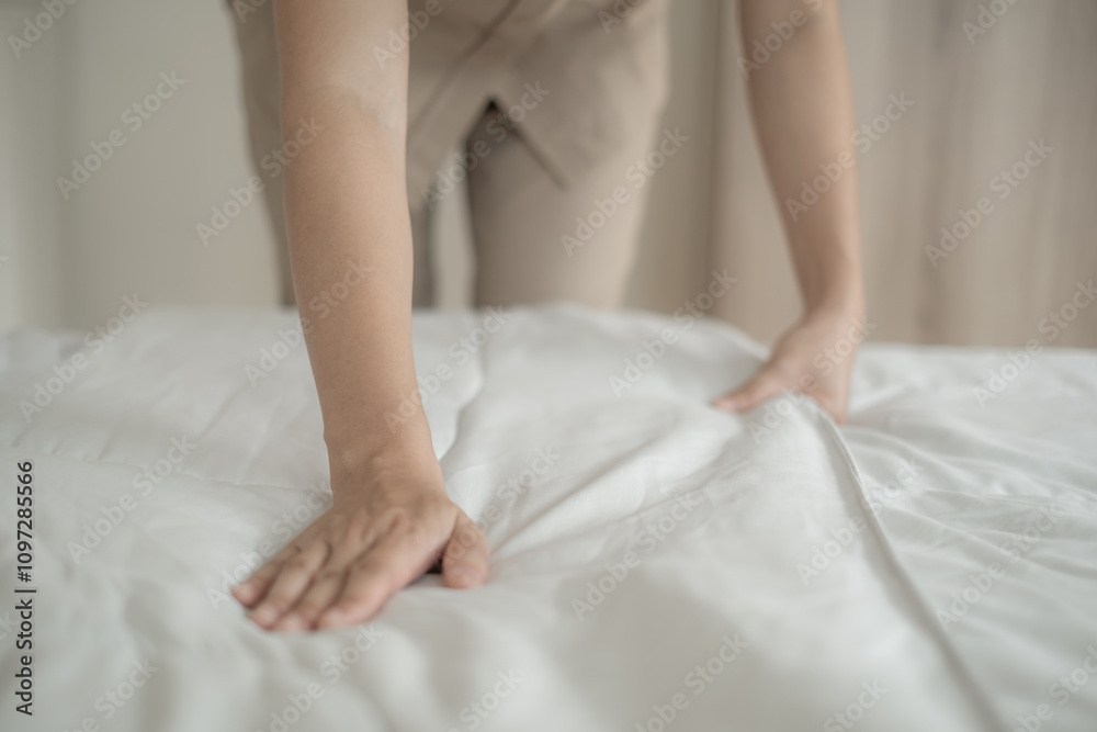 Hands of hotel maid making the bed in the luxury hotel room ready for tourist travel Hands of hotel maid making the bed in the luxury hotel room ready for tourist travel
