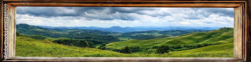 A plain wooden window frame, showcasing a scenic view of rolling hills and a cloudy sky.