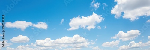 A bright blue sky with puffy, cotton-like clouds scattered across the cerulean canvas, sunshiny, fluffy, clouds