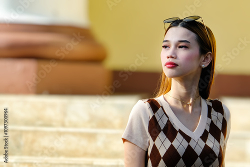 Closeup of a young and beautiful woman against a blurry background of a building