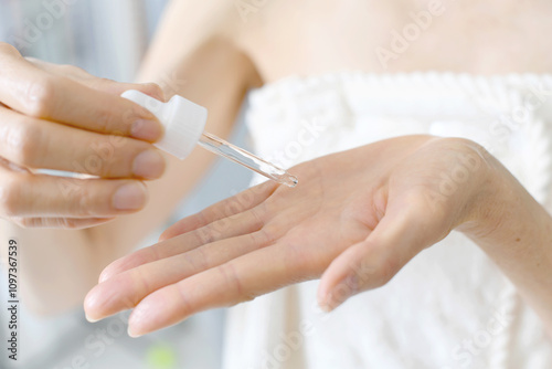 美容液を手に垂らす中年女性の手元