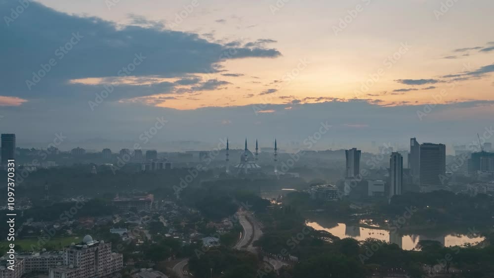 A tranquil morning view of the city, with the mosque standing tall against the backdrop of a vibrant sunrise. A tranquil morning view of the city, with the mosque standing tall against the backdrop of a vibrant sunrise.