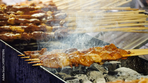 Chinese grilled lamb skewers (yang rou chuan) are a flavorful street food delicacy, featuring tender, marinated lamb seasoned with cumin, chili, and spices, char-grilled to perfection photo