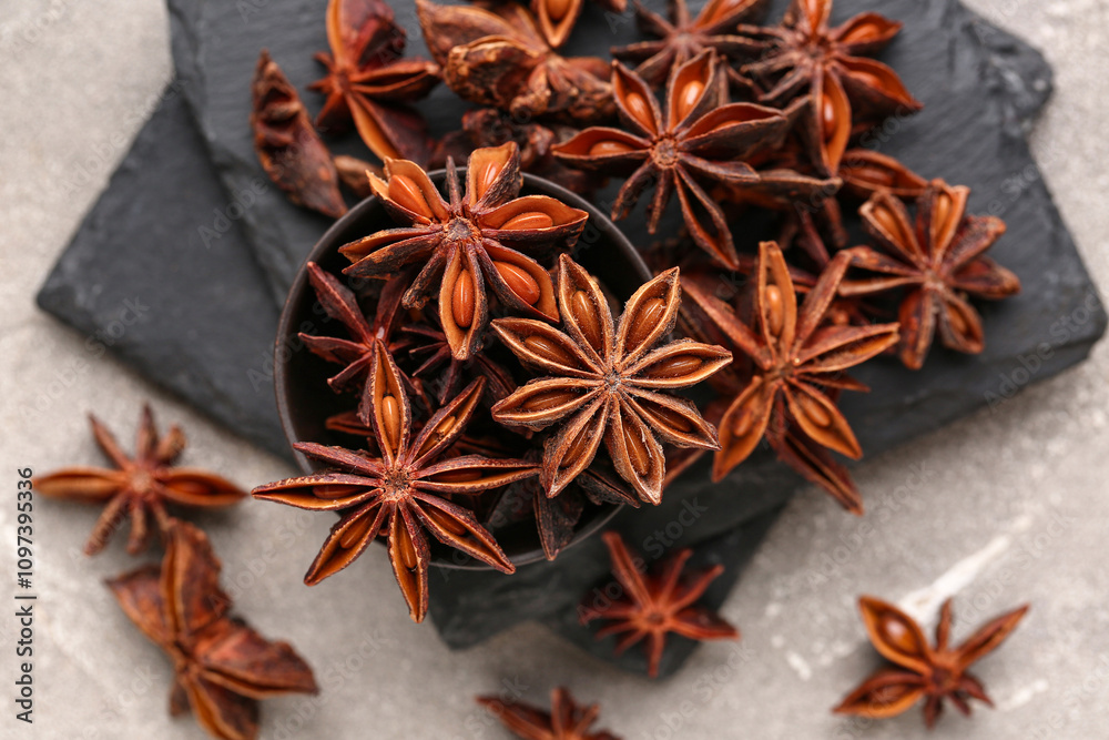 Slate boards with bowl of aromatic star anise on grunge background Slate boards with bowl of aromatic star anise on grunge background