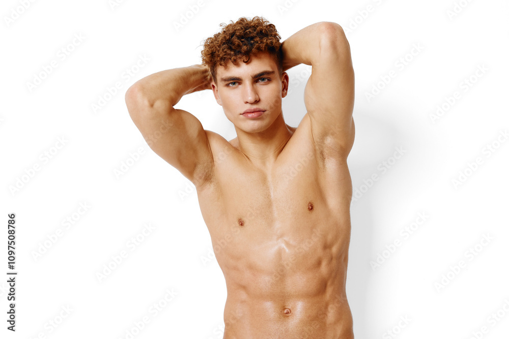 Fototapeta premium Confident young man posing shirtless against a white background, showcasing a toned physique and relaxed expression. Fitness and body concept.