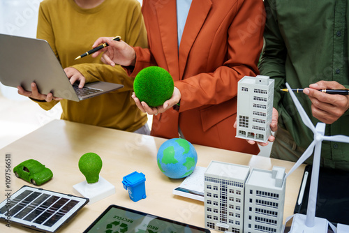 Asian business professionals discuss waste management and recycling strategies at desk, focusing on clean energy initiatives solar panels, electric cars, zero-waste solutions for sustainable future. photo