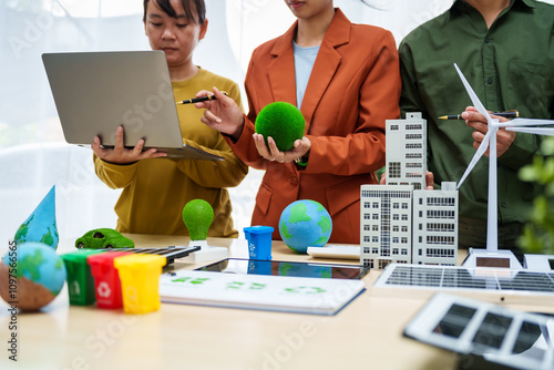 Asian business professionals discuss waste management and recycling strategies at desk, focusing on clean energy initiatives solar panels, electric cars, zero-waste solutions for sustainable future. photo