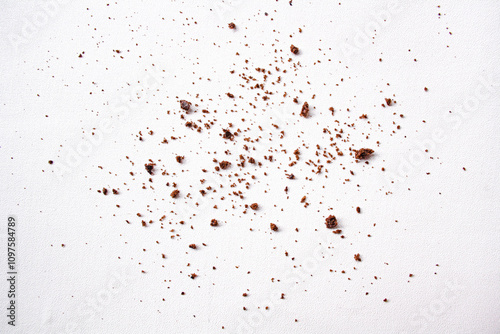 Scattered crumbs of chocolate biscuits on white background