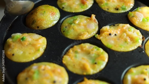 Appam or Mixed dal or Rava Appe South Indian dish preparation on iron pan photo