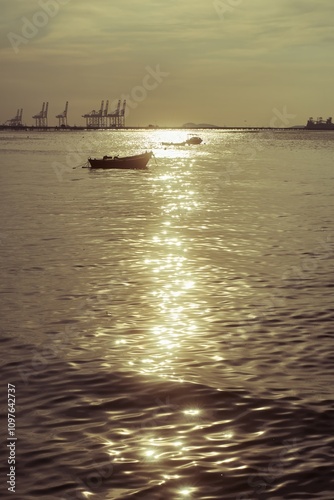 The ocean's mirror reflects the golden hues of the setting sun