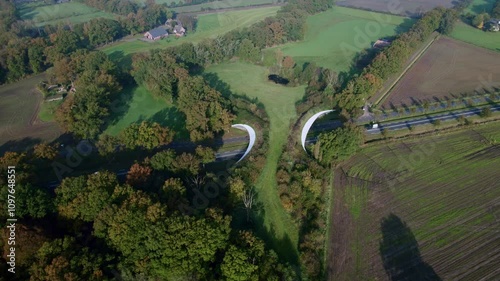 Road passing underneath Grimberg wildlife crossing forming a safe natural corridor bridge for animals to migrate between conservancy areas in agricultural countryside. photo