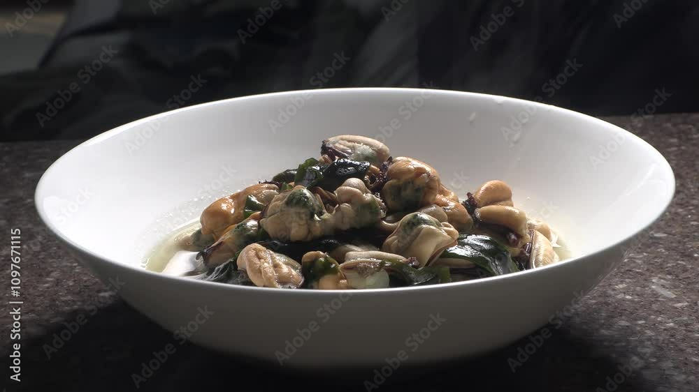 Mussel soup with steam in a white cooking bowl. Korean home-style seafood dishes.
Mussel soup with steam in a white cooking bowl. Korean home-style seafood dishes.