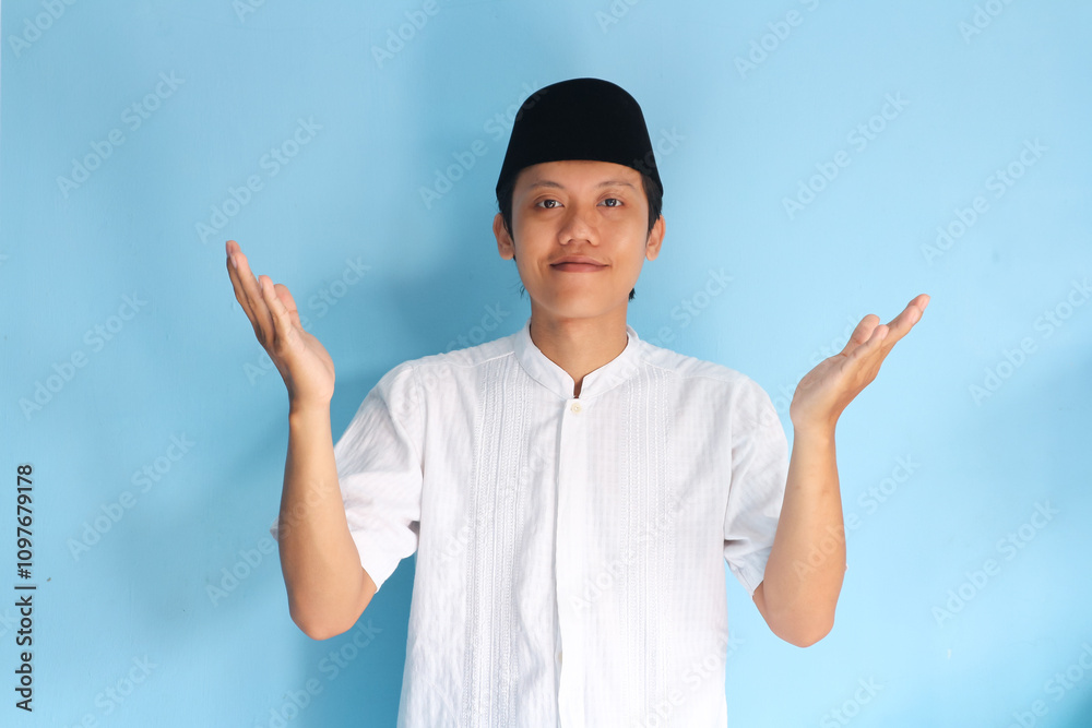Young Asian muslim man smiling happy standing with wide raised arms and welcoming ramadan Young Asian muslim man smiling happy standing with wide raised arms and welcoming ramadan