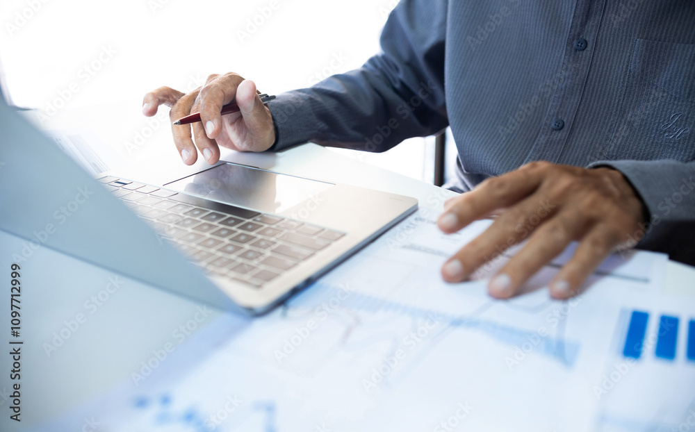 Asian businessman working with laptop and analyzing investment chart to start investment plan, business and investment analysis concept Asian businessman working with laptop and analyzing investment chart to start investment plan, business and investment analysis concept