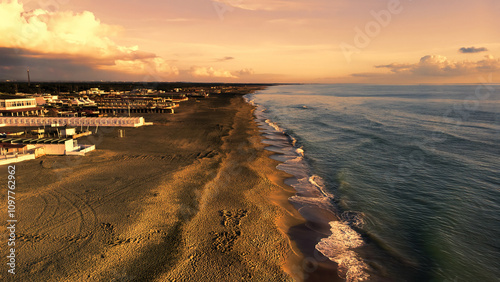 Aerial view over sea at Rome coastline with winter sky and bright sunset with closed beach facilities illuminated of natural sun lights