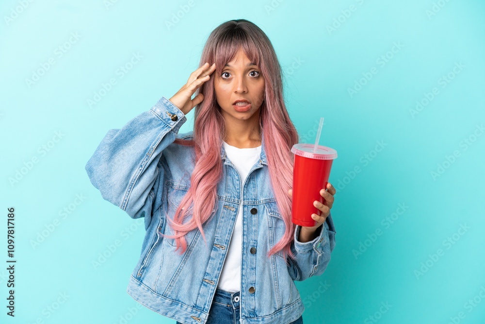 Young mixed race woman drinking a fresh drink isolated on blue background with surprise expression Young mixed race woman drinking a fresh drink isolated on blue background with surprise expression